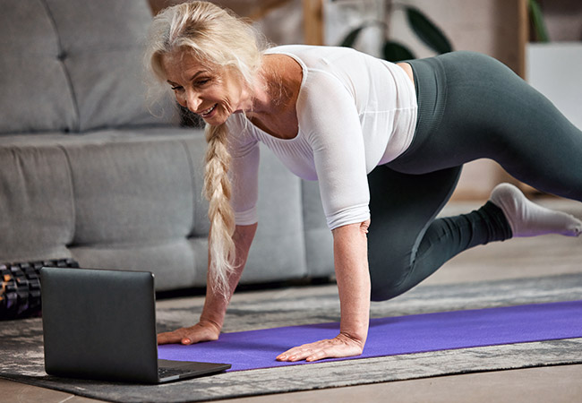 middle-aged woman doing online workout at home